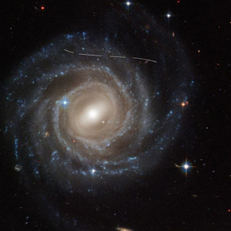 Esta imagen del Telescopio Espacial Hubble de la galaxia espiral barrada UGC 12158 parece como si alguien le hubiera tomado un rotulador blanco.