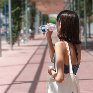 Archivo - Una joven bebe agua para refrescarse ante las altas temperaturas, a 24 de agosto en Sevilla (Andalucía, España). La ola de calor acaba este jueves con la llegada de una vaguada que bajará