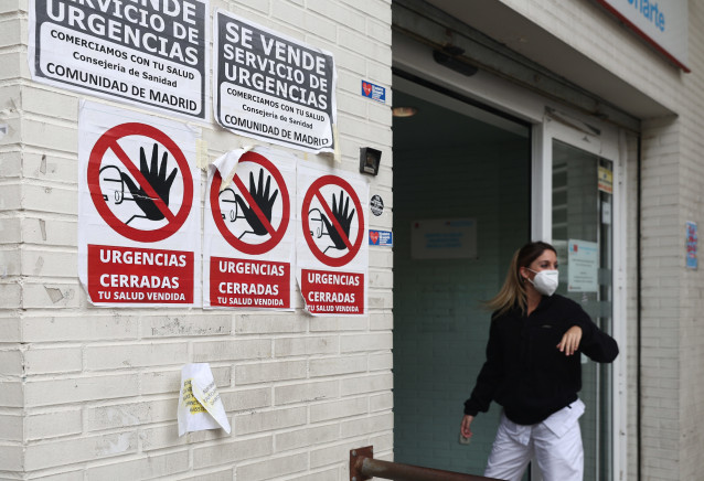 Una sanitaria con mascarilla en la puerta del Centro de Salud Ángela Uriarte, donde hay carteles de protesta que rezan 'Urgencias Cerradas, tu salud vendida', a 21 de octubre de 2022, en Madrid (España). La Comunidad de Madrid abrirá el próximo jueves 27