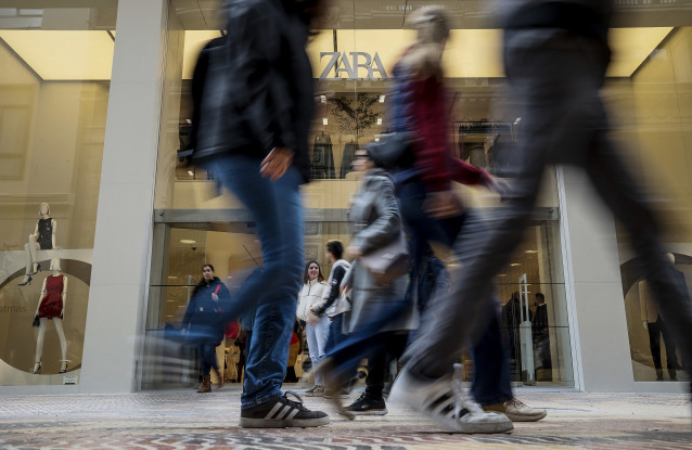 Archivo - Personas paseando delante de una macrotienda de Zara
