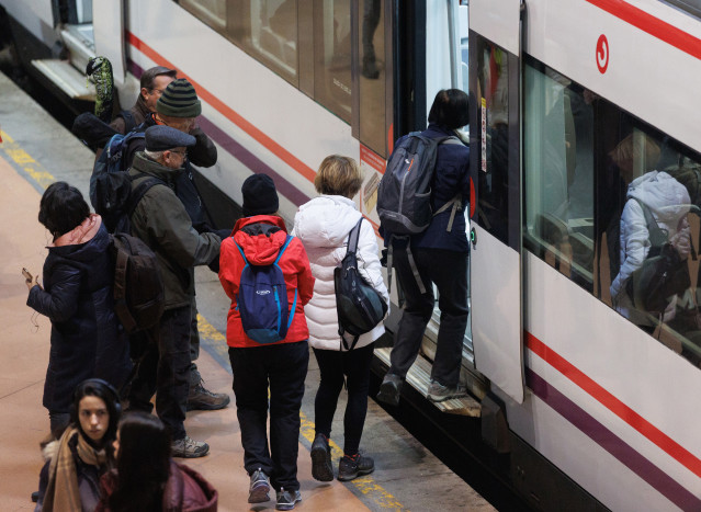 Varias personas sin mascarilla se suben a un vagón de un tren en la estación Puerta de Atocha-Almudena Grandes, a 8 de febrero de 2023, en Madrid (España).El uso de las mascarillas en los transportes públicos de España deja de ser obligatorio hoy, una vez