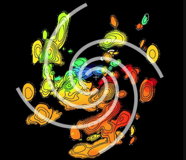 Mapa de la distribución de material en el disco de la protoestrella G358-MM1. El '+' blanco marca la ubicación de la protoestrella. Las líneas de contorno indican la intensidad de la señal. Los colores representan las velocidades en la línea de visión