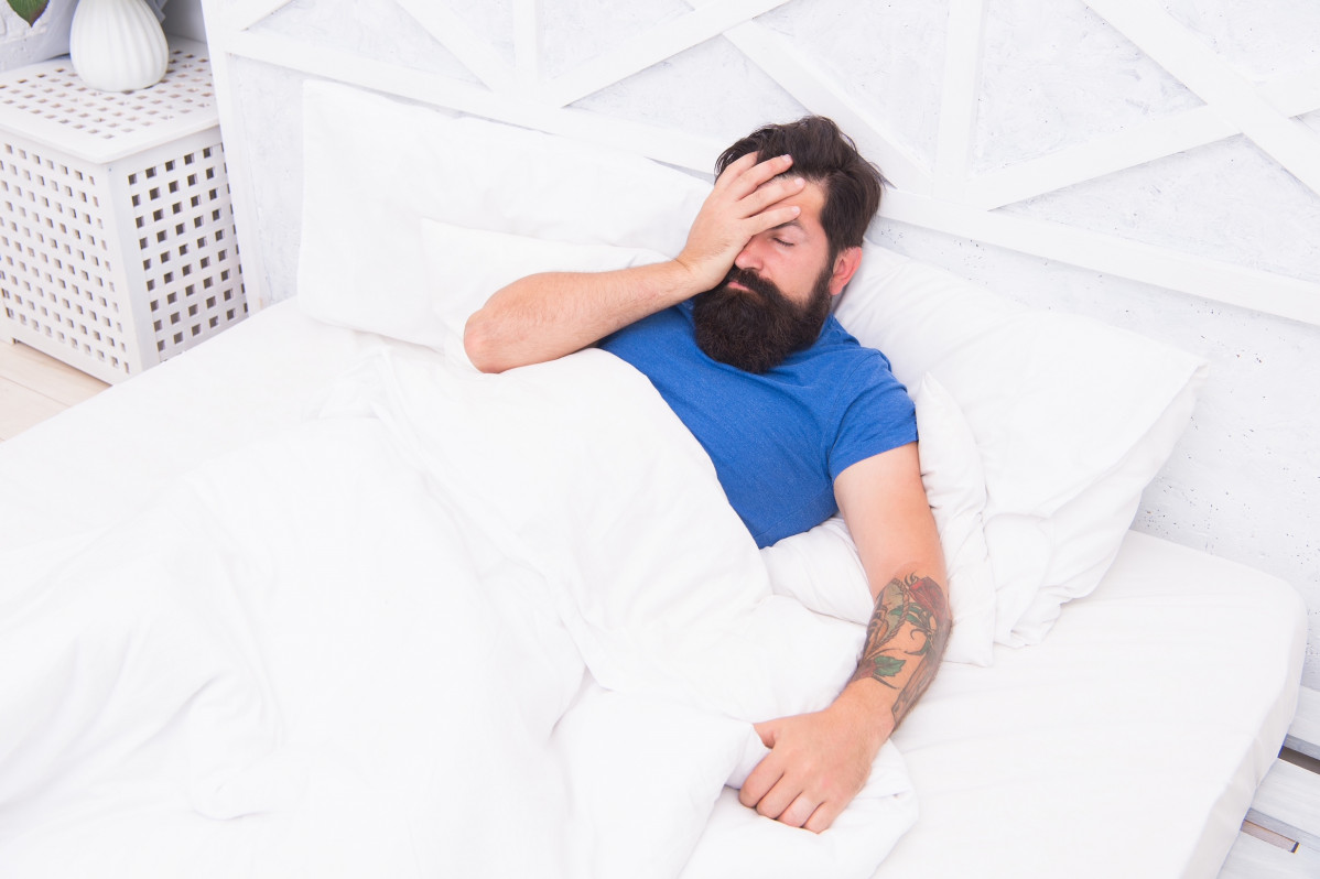 Oh no bachelor has hangover guy bedroom lazy sunday bed time routine brutal male wake up with headache relax lifestyle concept tired bearded man bed early wake up morning