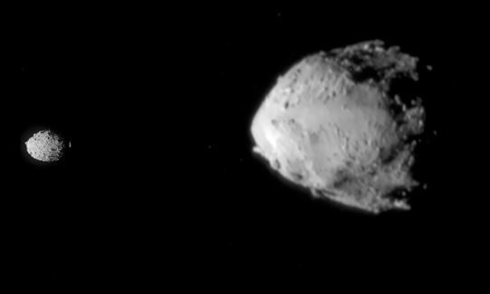 Dimorphos (a la izquierda), una pequeña luna de asteroide, orbita alrededor de un asteroide mayor llamado Didymos (a la derecha).