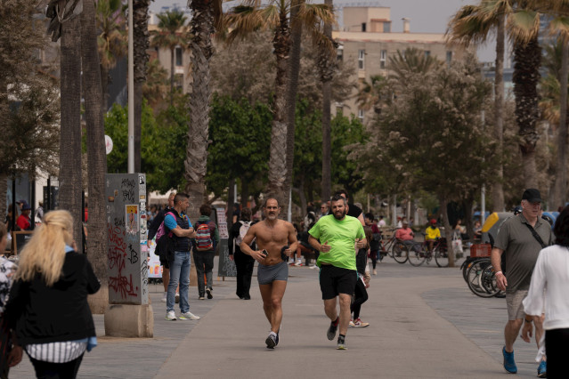 Varias personas aprovechan el buen tiempo para dar un paseo por el paseo marítimo de la playa de la Barceloneta, a 25 de abril de 2023, en Barcelona, Catalunya (España).