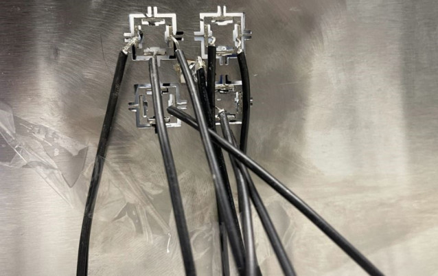 El metamaterial prototipo utiliza señales eléctricas transportadas por estos cables negros para controlar tanto la dirección como la intensidad de las ondas de energía que pasan a través de un material sólido.