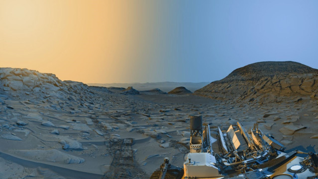 El rover Curiosity Mars de la NASA usó sus cámaras de navegación en blanco y negro para capturar panoramas de 'Marker Band Valley' en 2 momentos del día el 8 de abril. Se agregó color a una combinación de ambos panoramas para una interpretación artística.
