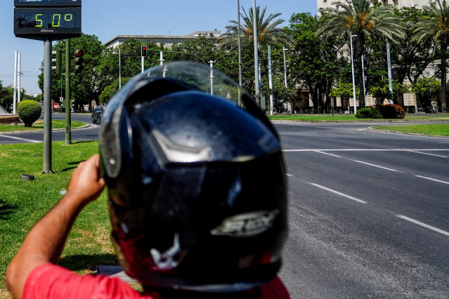 Transeúntes fotografían el termómetro situado en el Prado que marca 50 grados, a 26 de junio del 2023 en Sevilla (Andalucía, España).