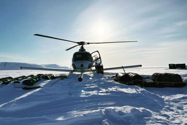Un helicóptero equipado con un radar de penetración en el hielo recarga combustible en el hielo en la isla Devon del Ártico.