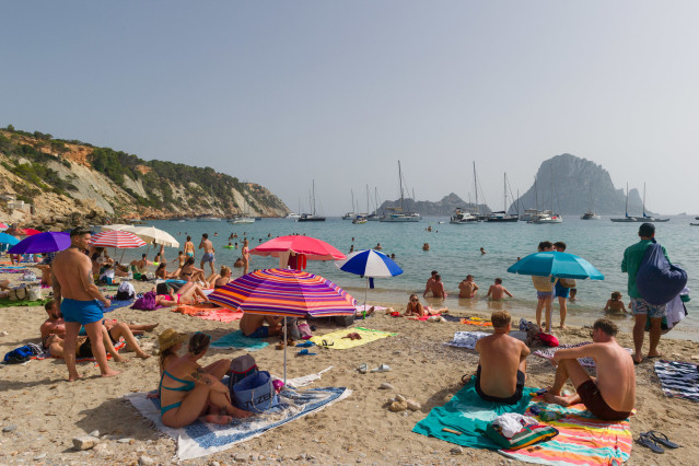 Varias personas en la playa de Cala d'Hort, a 11 de julio de 2023, en Ibiza, Islas Baleares (España). Los datos de la Federación Empresarial Hotelera de las Pitiusas indican que todas las zonas turísticas de la isla de Ibiza registraron grandes caídas de