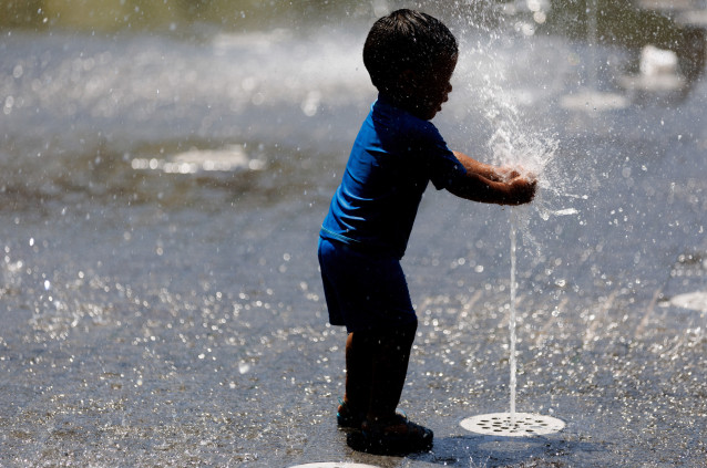 Un niño juega en una fuente