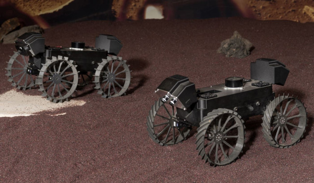 Un par de prototipos de plástico de los rovers CADRE demuestran la conducción en formación durante una prueba en el JPL el año pasado.