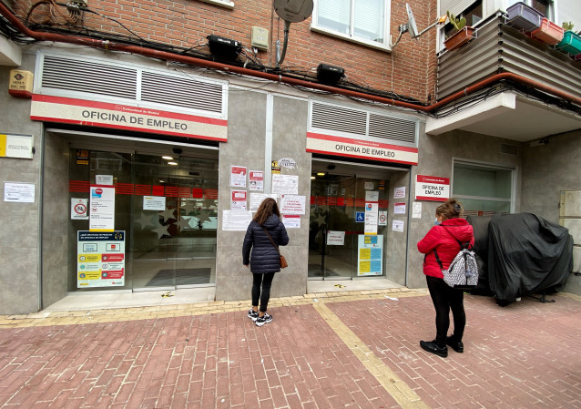 Archivo - Varias personas esperan para entrar en una Oficina de Empleo.