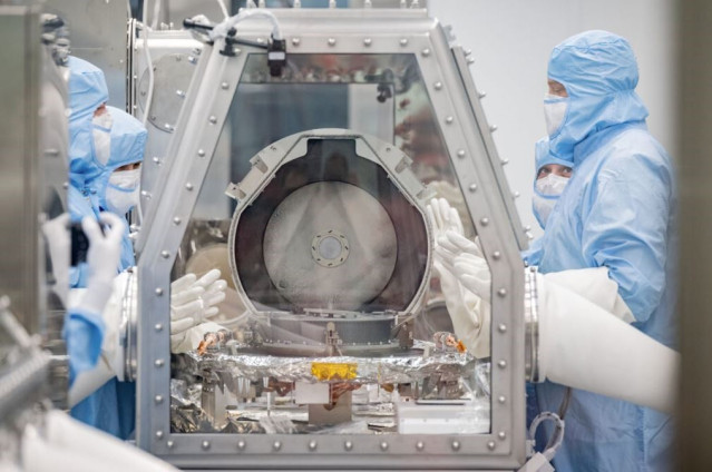 Los miembros del equipo de conservación de la NASA junto con los especialistas en recuperación de Lockheed Martin observan después de retirar con éxito la tapa del recipiente de retorno de muestras.