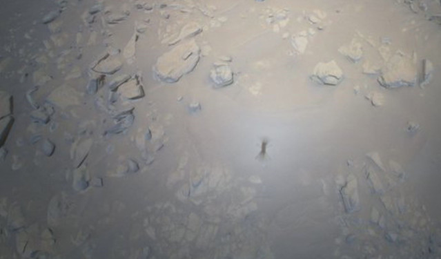 Imagen de Ingenuity en vuelo proyectada sobre el suelo de Marte