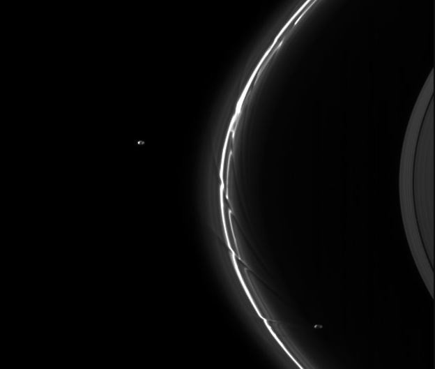 Imagen de la nave espacial Cassini de las lunas pastoras Pandora y Prometeo (cada una de aproximadamente 80 kilómetros de diámetro) actuando sobre el anillo F de Saturno.