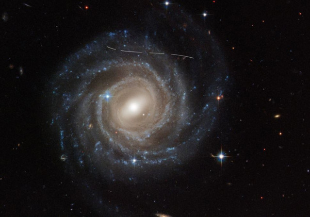 Esta imagen del Telescopio Espacial Hubble de la galaxia espiral barrada UGC 12158 parece como si alguien le hubiera tomado un rotulador blanco.