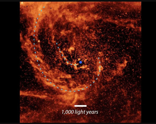 Esta vista de primer plano del centro de la galaxia de Andrómeda, tomada por el ya retirado Telescopio Spitzer de la NASA, está marcada con líneas de puntos azules para resaltar el camino de dos corrientes de polvo que fluyen hacia el agujero negro