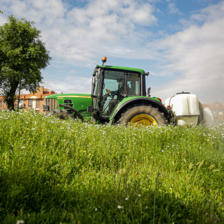 Archivo - Un agricultor montado en su tractor desinfecta las inmediaciones de Aranjuez