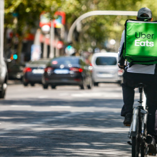 Archivo - Un 'rider' de la compañía Uber Eats, circula con su bicicleta por una calle de Madrid.