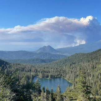 Una columna de humo de un incendio forestal se eleva sobre Castle Lake, cerca del monte Shasta, el 29 de junio de 2021.