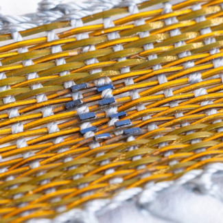Los investigadores cortaron y ensamblaron pequeñas células solares en placas de circuitos delgadas y flexibles antes de sellarlas en un polímero protector para crear una hebra similar a una fibra q