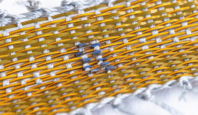 Los investigadores cortaron y ensamblaron pequeñas células solares en placas de circuitos delgadas y flexibles antes de sellarlas en un polímero protector para crear una hebra similar a una fibra que se tejió con nailon para formar un pequeño tejido.