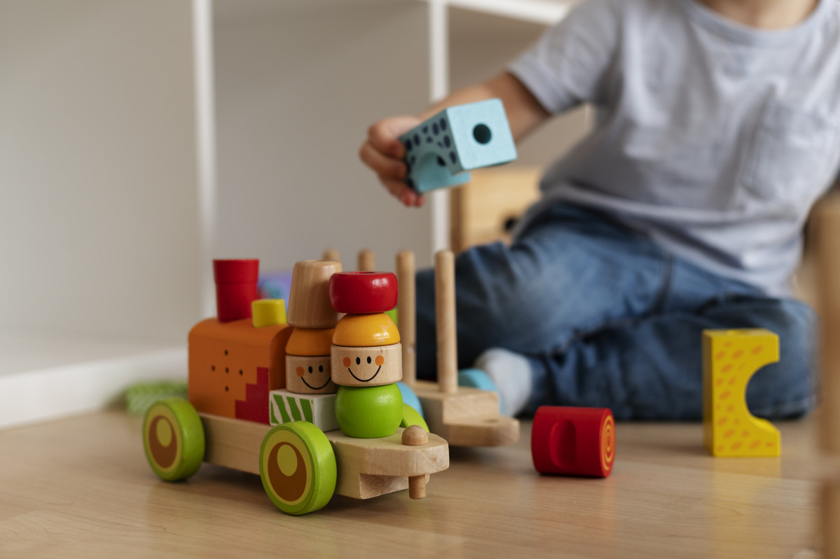 Front view kid playing with wooden toyds