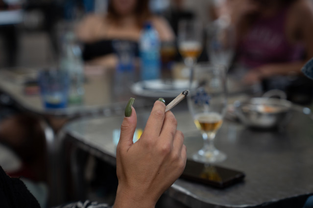 Archivo - Una mujer fuma sentado en la mesa de una terraza que una nueva normativa convertirá en espacio libre de humo por el Govern, en plaza de la Vila de Gràcia, a 23 de septiembre de 2022, en Barcelona, Catalunya (España). La nueva normativa consiste