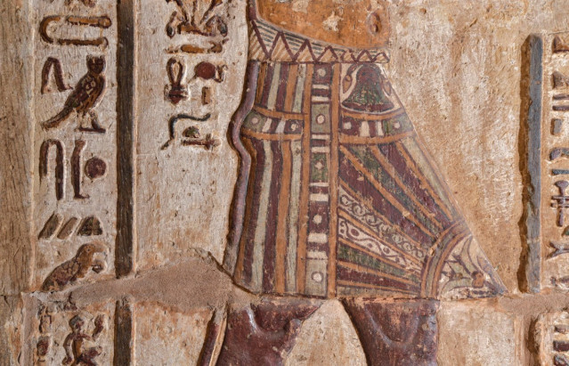 El mandil del rey con decoración vegetal. El papiro (arriba) es el emblema del Bajo Egipto y el lirio (abajo) el del Alto Egipto.