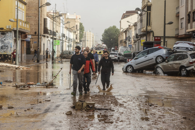 Varias personas recorren calles llenas de agua y barro tras el paso de la DANA por el barrio de La Torre de Valencia, a 30 de octubre de 2024, en Valencia, Comunidad Valenciana (España). La Comunitat Valenciana ha registrado la gota fría 'más adversa' del