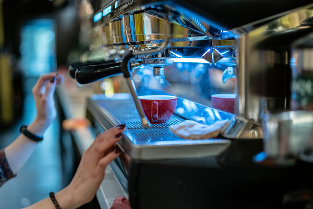 Archivo - Un trabajador prepara un café.