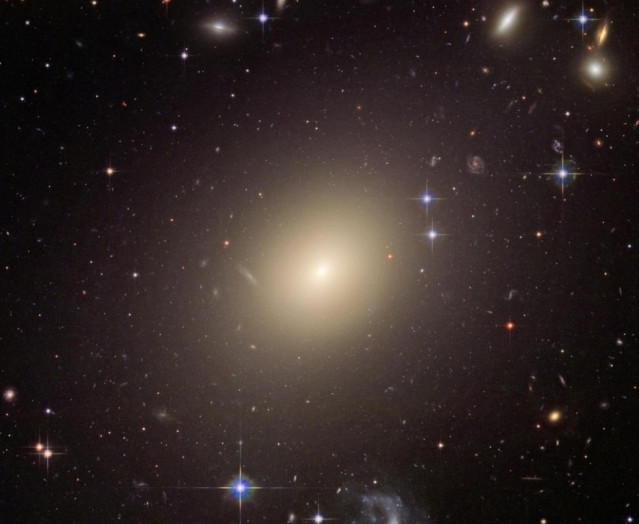 La enorme galaxia elíptica ESO 325-G004 brilló 10.000 veces más cuando se formó que hoy. Este tipo de galaxias iluminó brevemente todo el universo y contribuyó a la radiación de fondo que podemos medir hoy.