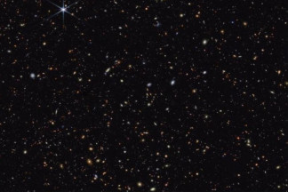 En esta imagen de campo profundo del Telescopio Espacial James Webb, aparecen galaxias distantes dispersas por el cielo nocturno. Las galaxias más distantes aparecen como pequeños puntos rojizos, o 