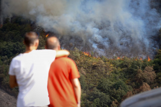 Varias personas observan el incendio, en la sierra de O Courel, a 19 de agosto de 2025, en Quiroga, Lugo, Galicia (España). El fuego amenaza la sierra de O Courel en su avance desde la localidad luce