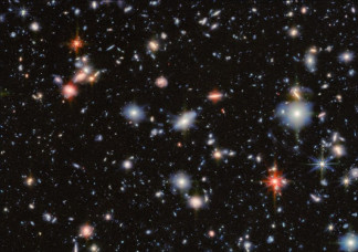 Esta imagen combina datos de las cámaras MIRI y NIRcam del JWST para crear una vista multicolor del Campo Ultraprofundo del Hubble. Los tonos verdes, naranjas y rojos provienen de MIRI y revelan las 