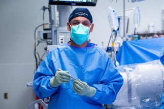 Joseph Osorio, neurocirujano de UC San Diego Health (EEUU), sostiene el primer implante de columna cervical anterior totalmente personalizado del mundo, creado mediante imágenes avanzadas, planificac