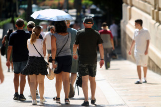 Viandantes soportan las altas temperaturas por las calles de Málaga, A 12 de agosto de 2025 en Málaga, Andalucía (España). La Agencia Estatal de Meteorología (Aemet) ha emitido un aviso por altas