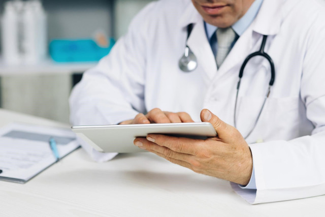 Archivo - Doctor consultando una tablet.