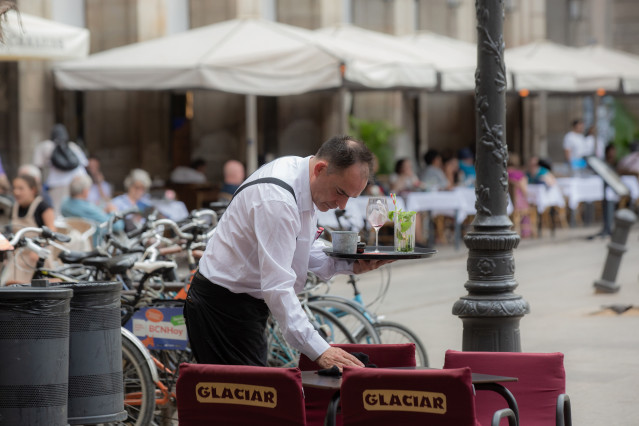 Archivo - Un camarero limpia una mesa en la plaza Real de Barcelona, Cataluña (España).