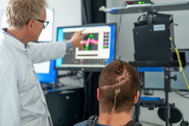 Archivo - El profesor Simon Jacob y el participante del estudio Michael Mehringer analizan los datos obtenidos mediante una interfaz cerebro-ordenador.