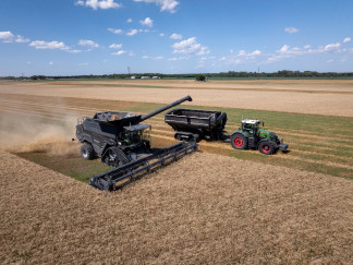 This image, taken during the 2024 AGCO Tech Day, shows PTx Trimble’s OutRun solution in action: an autonomous Fendt tractor pulls a grain cart alongside an IDEAL combine during offloading. AGCO’s 
