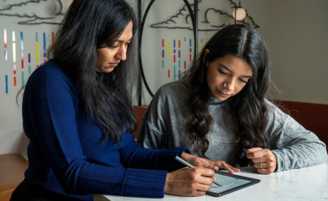 Dos mujeres revisando un texto en un lector Kindle