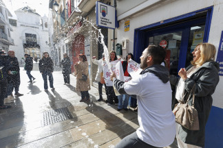 La administracion de Loterías de la calle Isabel la Católica de Santa Fe (Granada) reparte el tercer premio del sorteo de Navidad entre sus vecinos, que han descorchado champán