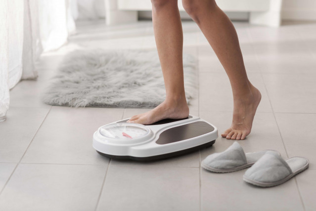 Imagen de recurso de una mujer en una báscula.