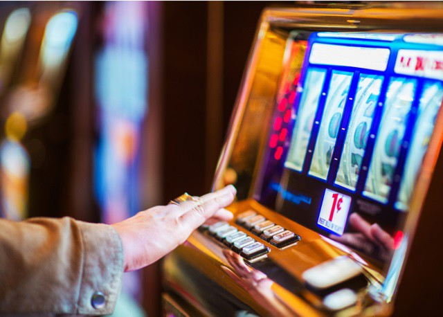 Archivo - Imagen de una persona jugando a una máquina de juegos de azar.