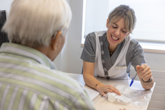 Enfermera recibe a paciente en consulta.