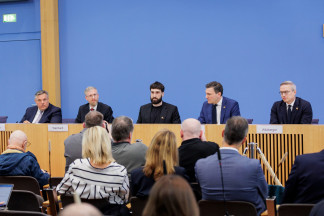 Rolf Schumann (Schwarz Digits), Samuel Weinbach (Aleph Alpha), Aidan Gomez (Cohere) y representantes de los gobiernos de Alemania y Canadá.