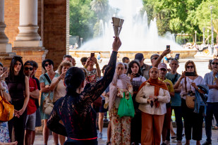 Los turistas contemplan un espectáculo flamenco en la Plaza de España de Sevilla en una jornada primaveral.