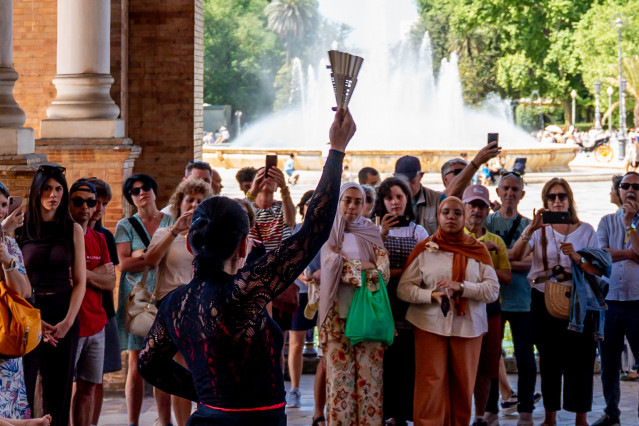Los turistas contemplan un espectáculo flamenco en la Plaza de España de Sevilla en una jornada primaveral.